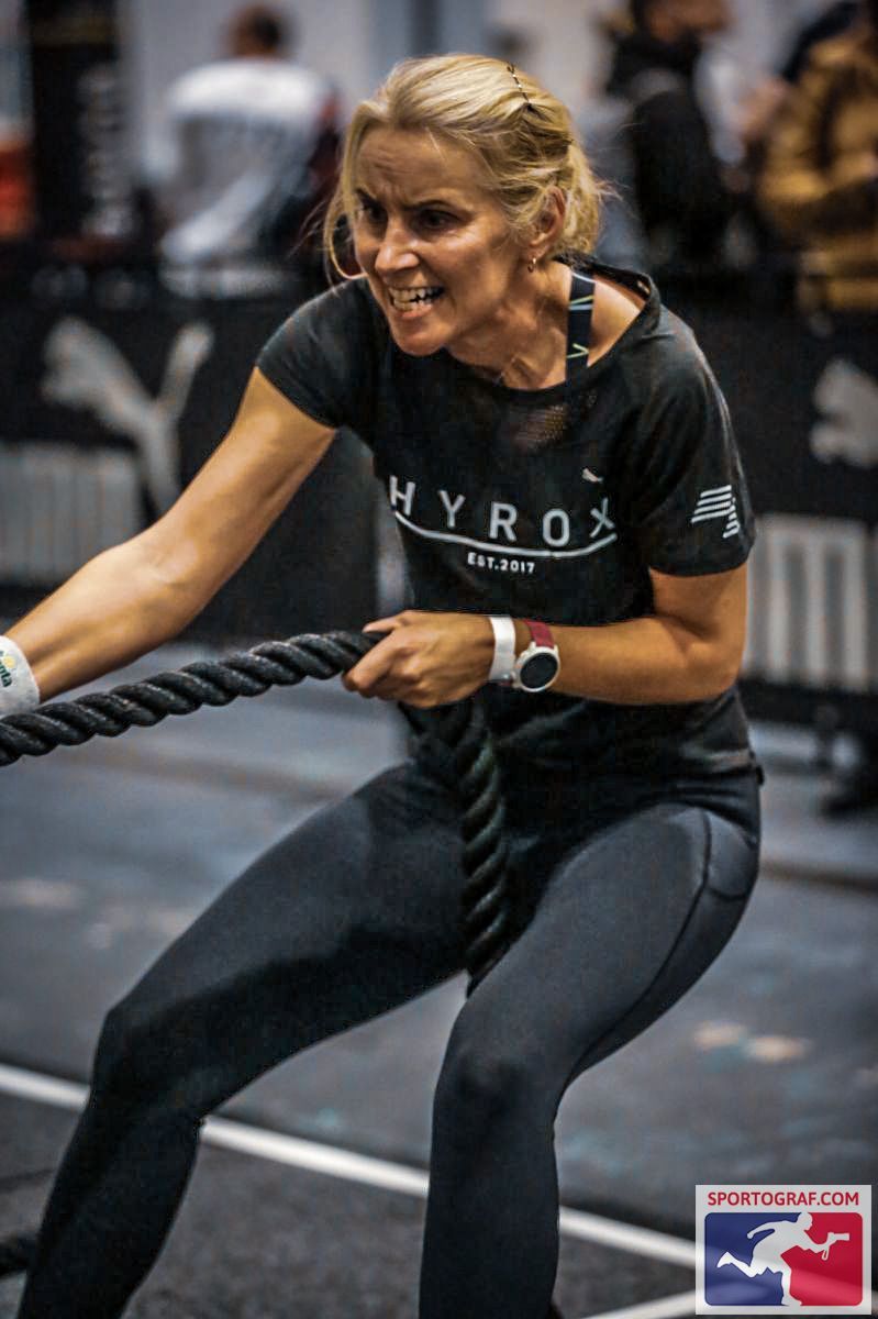 Juliet pulling a heavy rope at a HYROX fitness race
