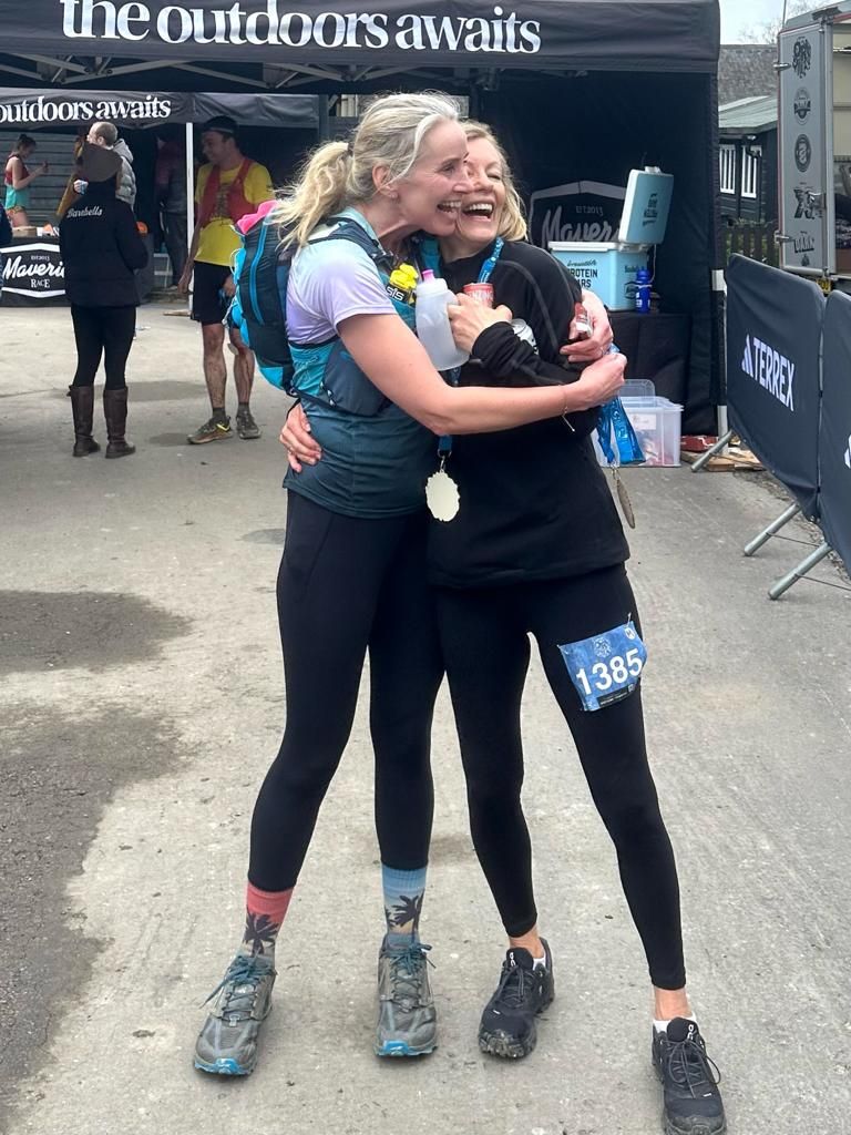 Juliet hugging a friend at a trail race finish